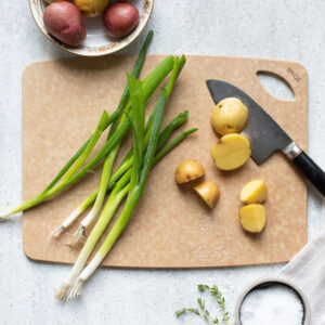 Top view of Sage 9"x12" Cutting Board with potatoes and green onions