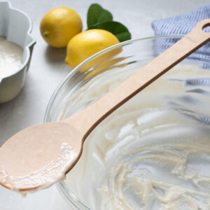 Sage Woodfiber Spoon on a bowl next to two lemons.