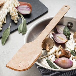 Sage Saute Tool on a dish with mushrooms and onions.